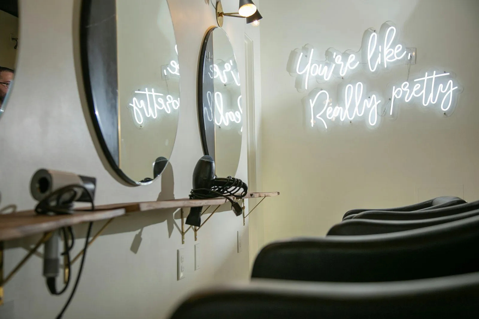 Salon z lustrami i świecącym napisem na ścianie